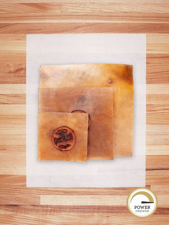 three beef hide chips stacked on a butcher block countertop