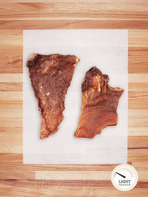 two light brown pieces of beef tripe on a butcher block countertop