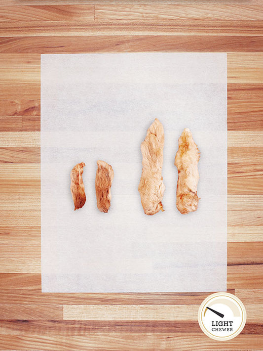 four white small and large rabbit feet on a butcher block countertop