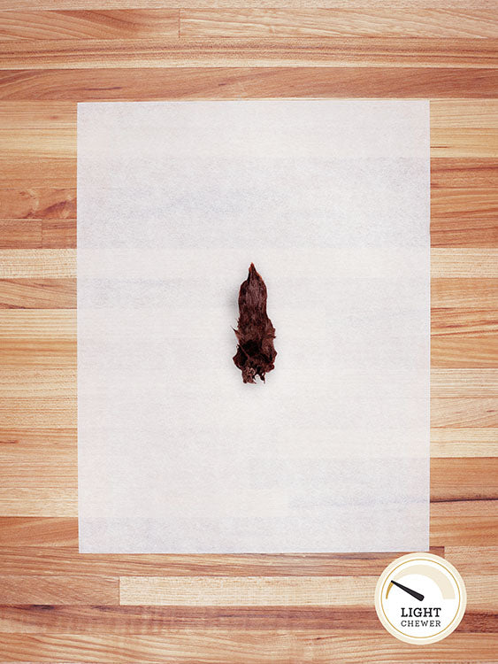 small brown rabbit foot on a butcher block countertop