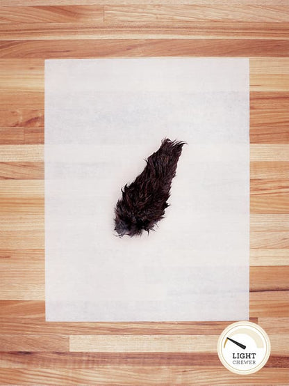 black rabbit tail with hair on butcher block countertop