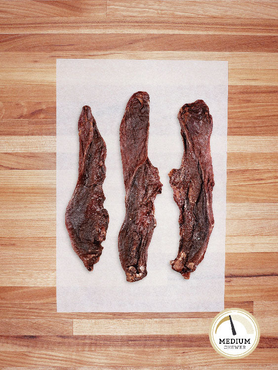 three hog tongues on a butcher block countertop